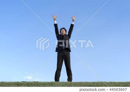 一名年輕人將手伸向天空映襯著藍天。成功·貿易公司·力量·挑戰形象 44503607