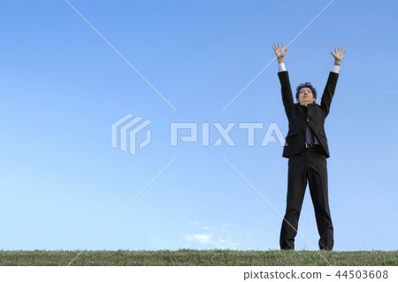 One young man who spreads hands to the sky against the blue sky. Success · trading company · power · challenge image 44503608