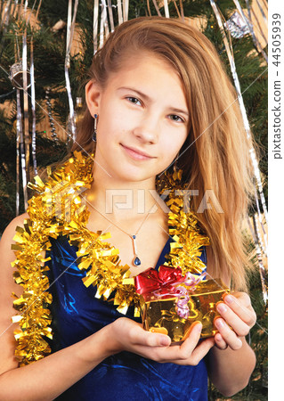 Beautiful happy teen girl holds before itself a Christmas gift 44505939