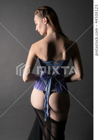 Slim brunette in corset in the dark rearview Slim brunette in corset in the dark rearview 44508123