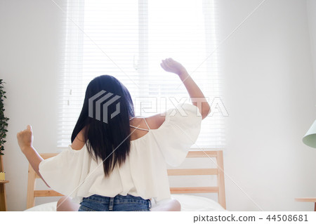 Get up and stretch. Asian woman stretching in bed after wake up. Get up and stretch. Asian woman stretching in bed after wake up. 44508681