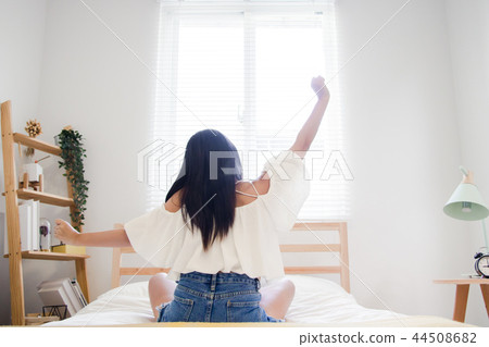 Get up and stretch. Asian woman stretching in bed after wake up. 44508682
