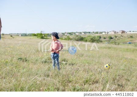 mother and young son catch butterflies in the park for a walk 44511802