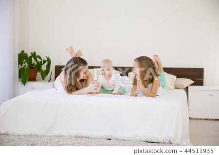 three girls play sisters in the bedroom on the bed in the morning 44511935