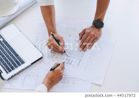 Architect or Engineer meeting working with partner on blueprint 44517972