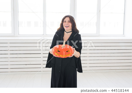 Halloween and holidays concept - Witch woman with Jack O'Lantern pumpkin Halloween and holidays concept - Witch woman with Jack O'Lantern pumpkin 44518144
