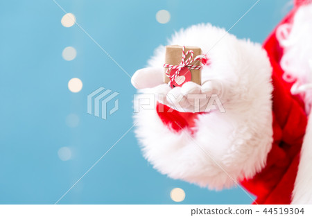 Santa holding a small Christmas gift 44519304