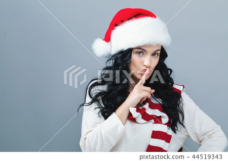 Young woman with Santa hat making a quiet gesture 44519343