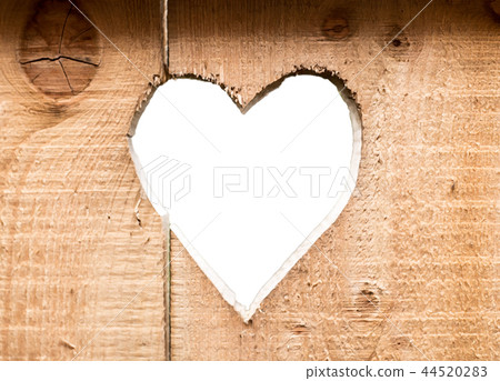 Heart carved in dark wooden wall texture, with bokeh background isolated Heart carved in dark wooden wall texture, with bokeh background isolated 44520283