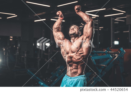 Handsome model muscle man abs workout in gym Handsome model muscle man abs workout in gym 44520654