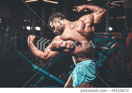 Handsome model muscle man abs workout in gym Handsome model muscle man abs workout in gym 44520672