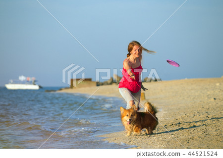 girl playing with a dog on the beach girl playing with a dog on the beach 44521524