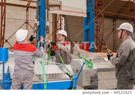manufacture workshop. move the crane with beam. Workers adjusts the machine in the warehouse. the 44521825