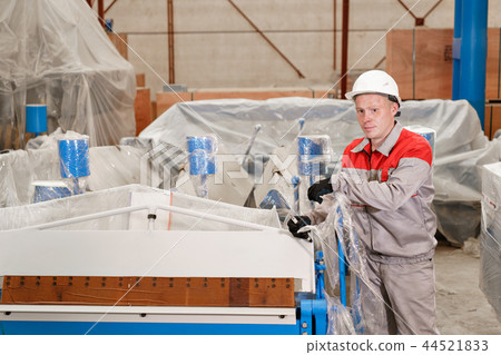 manufacture workshop. Worker unpacks the machine in the warehouse. the production of ventilation and 44521833