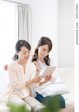 Mother and daughter looking at the tablet 44525963
