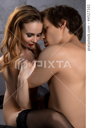 Young naked couple in steamy embrace against wall 44527101
