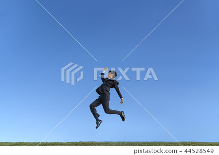 A young businessman in a suit who jumps against the blue sky. Health, health, development, challenge image 44528549