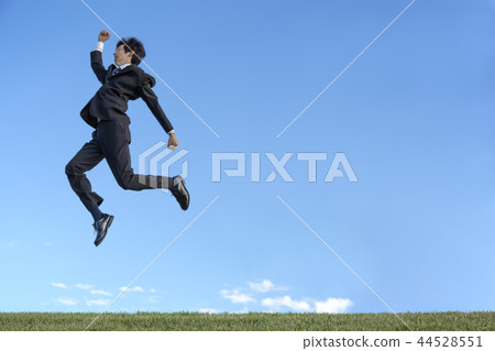 在跳躍反對藍天的衣服的一個年輕商人。健康，健康，發展，挑戰形象 44528551