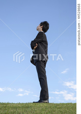 認為對角地向上反對藍天的商人的側視圖全長畫象。希望/夢想/展望/免費圖像 認為對角地向上反對藍天的商人的側視圖全長畫象。希望/夢想/展望/免費圖像 44528668