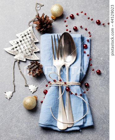 Christmas and New Year holiday table place setting decorations. Grey background. Top view. Christmas and New Year holiday table place setting decorations. Grey background. Top view. 44529023