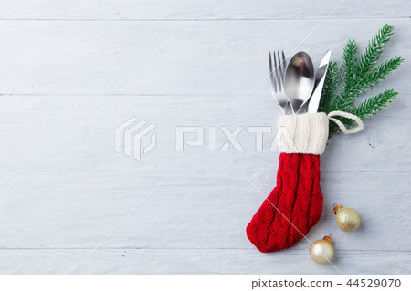 Christmas, New Year celebration. Knitted sock with cutlery and decoration. Copy space. Top view. 44529070
