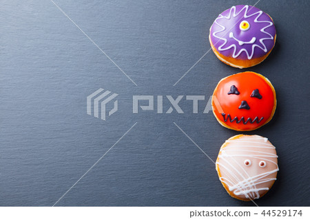 Donuts with Halloween decoration, icing on black slate background. Top view. Copy space. 44529174