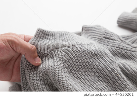 Hand holding a sweater 44530201