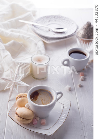 Tasty sweet macarons and coffee cup on white wooden background. Cristmas concept lazy morning, warm Tasty sweet macarons and coffee cup on white wooden background. Cristmas concept lazy morning, warm 44532870