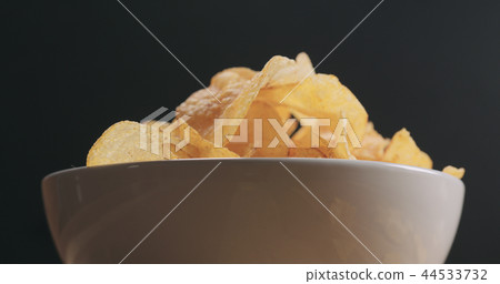 closeup potato chips in white bowl low angle shot closeup potato chips in white bowl low angle shot 44533732