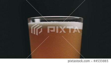 Closeup light ale beer with bubbles over black background 44533865