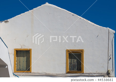 White building with yellow windows frames, Greece 44538681