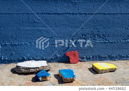 Bright sky blue textured wall and colorful stones 44538682
