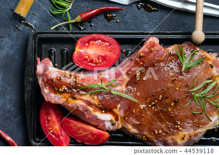 Marinating raw lamb chops with spices, honey and tomato on grill pan, close up Marinating raw lamb chops with spices, honey and tomato on grill pan, close up 44539118