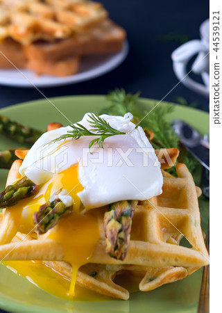Grilled waffle with Green boiled Asparagus with Poached Egg, with salt and spices on ceramic plate 44539121