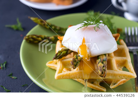 Grilled waffle with Green boiled Asparagus with Poached Egg, with salt and spices on ceramic plate Grilled waffle with Green boiled Asparagus with Poached Egg, with salt and spices on ceramic plate 44539126