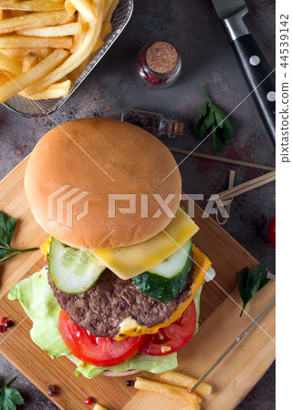 Tasty grilled home made burger cooking with beef, tomato, cheese, cucumber and lettuce. Top view 44539142