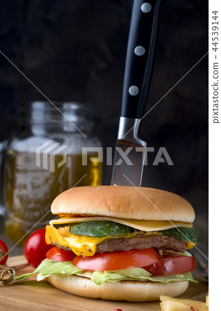 delicious homemade burger used to chop beef. on the wooden table. The burgers are inserted knives delicious homemade burger used to chop beef. on the wooden table. The burgers are inserted knives 44539144