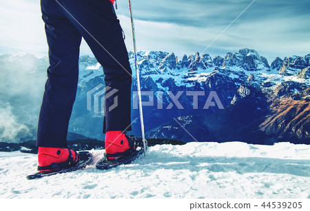 Man legs with snowshoes walk in snow in winter 44539205