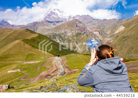 girl looking in binoscope directed towards the snowy mountain tops of Kazbeg from the view point 44539218