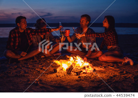 young friends have picnic with bonfire on the beach young friends have picnic with bonfire on the beach 44539474