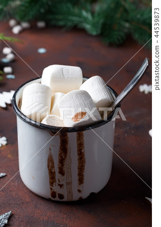 Winter hot drink close up. Hot chocolate or cocoa with marshmallow and spices on dark stone Winter hot drink close up. Hot chocolate or cocoa with marshmallow and spices on dark stone 44539873
