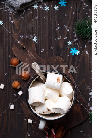 Christmas winter still life : a cup of cocoa with marshmallows sprinkled with nuts , fir cones on a Christmas winter still life : a cup of cocoa with marshmallows sprinkled with nuts , fir cones on a 44539876