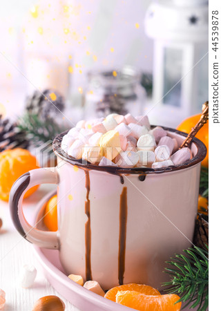 Enamel cup of hot cocoa with mini marshmallows with pine boughs against a white background with Enamel cup of hot cocoa with mini marshmallows with pine boughs against a white background with 44539878