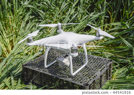 Quadrocopters on a plastic box in the grass Quadrocopters on a plastic box in the grass 44541916