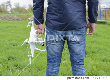 A man with a quadrocopter in his hands. White kvadrokopter prepare for flight A man with a quadrocopter in his hands. White kvadrokopter prepare for flight 44541963