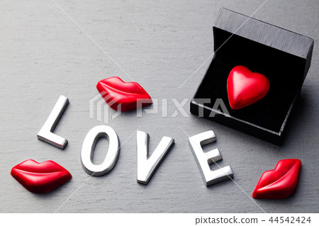 Love word, heart and lips shaped chocolate candies. Slate background. Copy space. Top view. 44542424