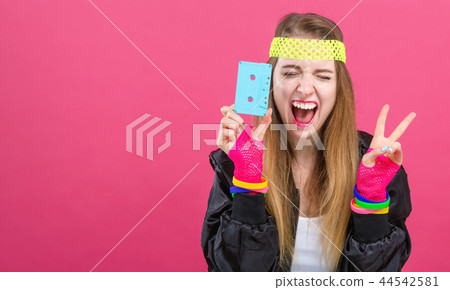 Woman in 1980's fashion holding a cassette tape 44542581