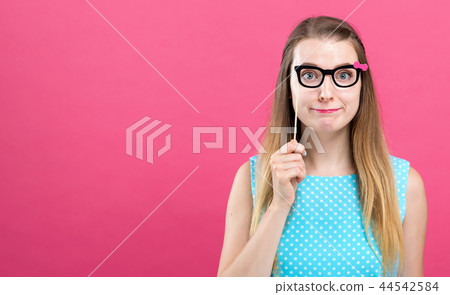 Young woman holding a paper glasses party stick 44542584