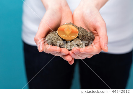 Woman with a ethereum with raw gold nuggets Woman with a ethereum with raw gold nuggets 44542912