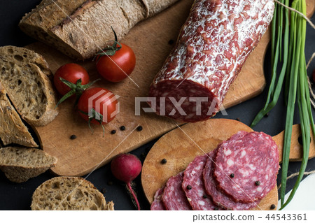 Dark background with bread and sausage pieces Dark background with bread and sausage pieces 44543361